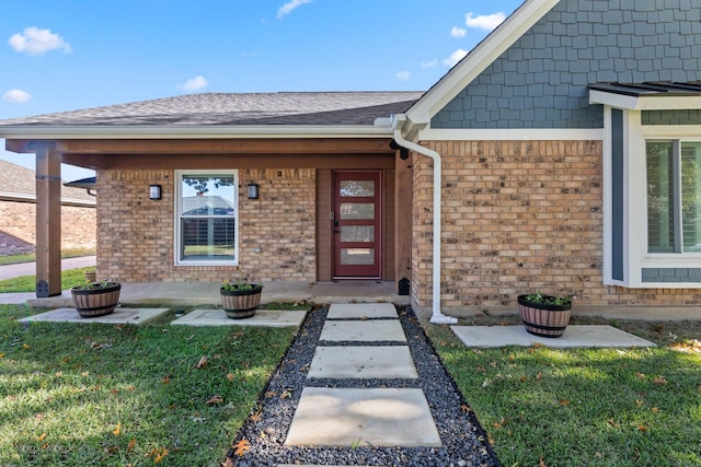 view of exterior entry with a lawn