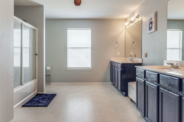 bathroom with enclosed tub / shower combo, plenty of natural light, and vanity