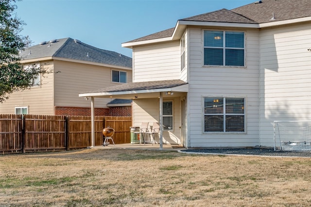 back of property with a lawn and a patio