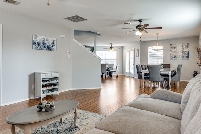 living room with a ceiling fan, visible vents, and a wealth of natural light