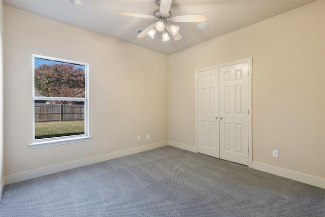 unfurnished bedroom with ceiling fan, a closet, and carpet flooring