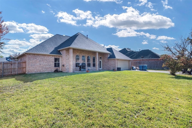 back of house with a garage and a lawn