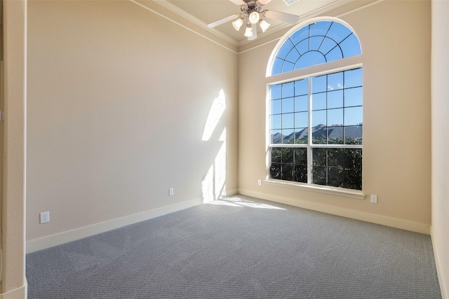 carpeted empty room featuring ceiling fan, a high ceiling, and crown molding