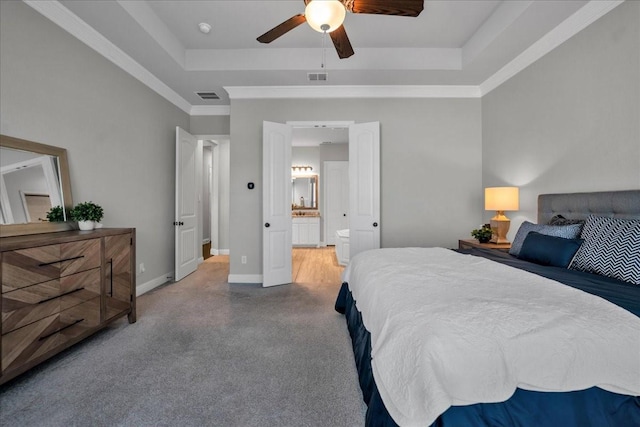 bedroom featuring ensuite bathroom, crown molding, ceiling fan, and a tray ceiling