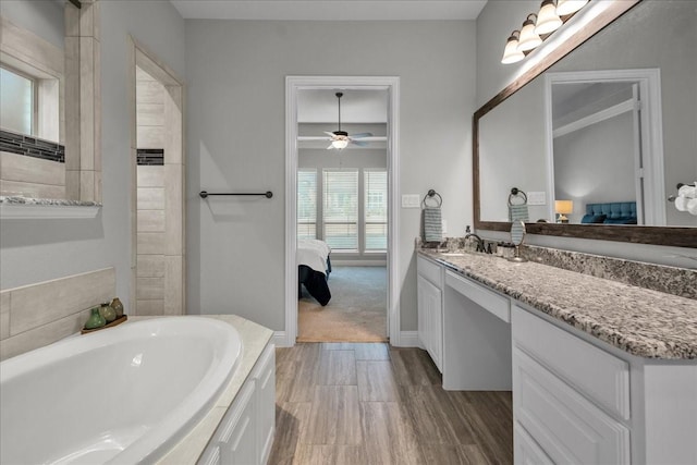 bathroom featuring vanity, hardwood / wood-style flooring, a bathing tub, and ceiling fan