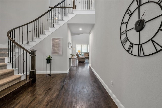 entrance foyer with dark hardwood / wood-style floors and a high ceiling