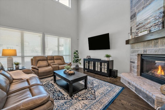 living room featuring a high ceiling, a large fireplace, and dark hardwood / wood-style floors