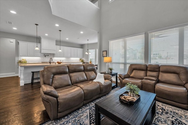 living room with sink, a chandelier, and dark hardwood / wood-style flooring