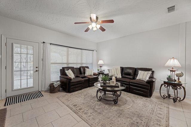 tiled living room with ceiling fan and a textured ceiling