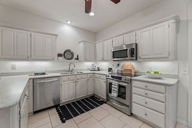 kitchen featuring white cabinets, light tile patterned flooring, sink, and appliances with stainless steel finishes