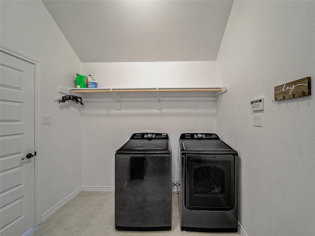 washroom featuring washing machine and dryer and a textured ceiling