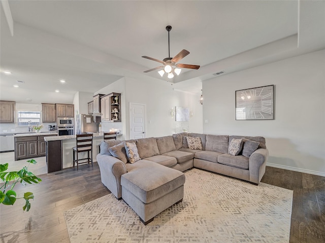 living room featuring ceiling fan, sink, and hardwood / wood-style flooring