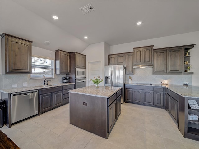 kitchen with decorative backsplash, dark brown cabinetry, stainless steel appliances, a center island, and lofted ceiling