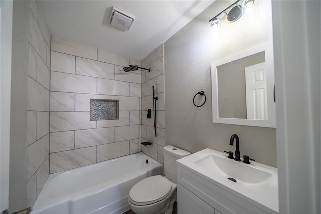 full bathroom with vanity, tiled shower / bath combo, and toilet