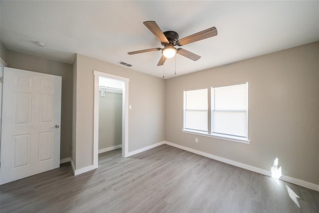 unfurnished bedroom with ceiling fan, light hardwood / wood-style floors, and a closet