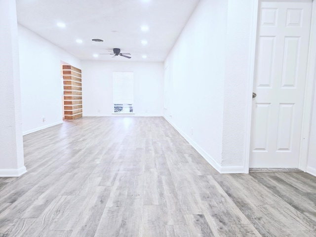 unfurnished living room featuring ceiling fan and light wood-type flooring