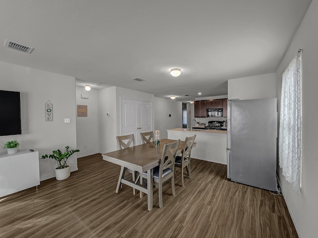 dining room with dark wood-type flooring and sink