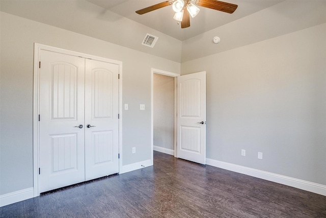 unfurnished bedroom with ceiling fan, dark hardwood / wood-style floors, vaulted ceiling, and a closet