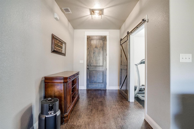 foyer with dark hardwood / wood-style flooring and a barn door