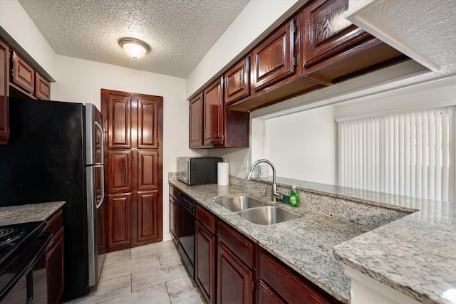 kitchen with sink, light stone counters, a textured ceiling, light tile patterned floors, and black appliances