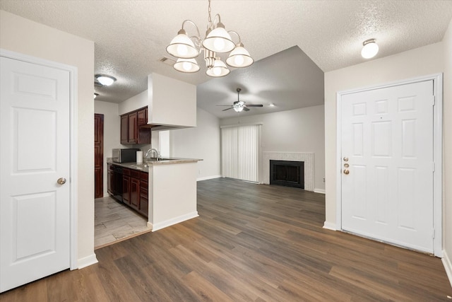 kitchen featuring dark wood-type flooring, ceiling fan with notable chandelier, sink, a textured ceiling, and dark brown cabinetry