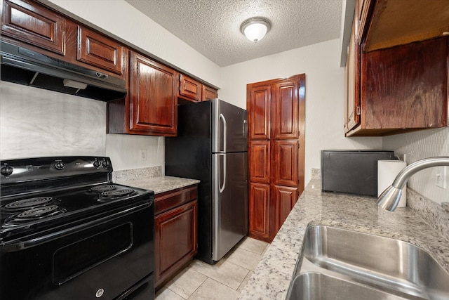 kitchen featuring a textured ceiling, black range with electric cooktop, sink, light tile patterned floors, and stainless steel refrigerator