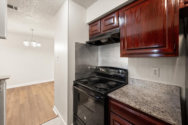 kitchen featuring light stone countertops, light wood-type flooring, an inviting chandelier, black electric range, and hanging light fixtures