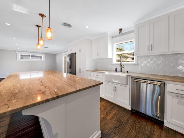 kitchen with appliances with stainless steel finishes, a center island, and white cabinetry