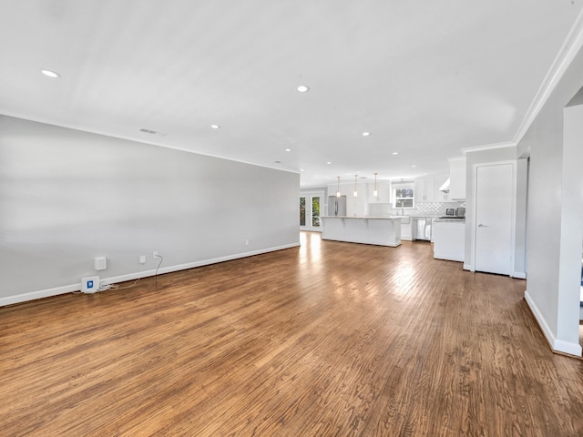 unfurnished living room featuring crown molding and wood-type flooring