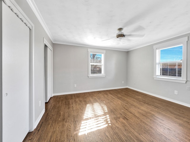 unfurnished bedroom featuring ceiling fan, crown molding, and dark wood-type flooring