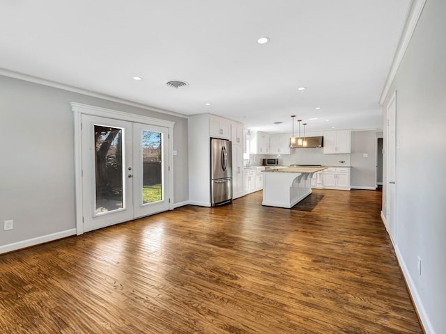 kitchen featuring stainless steel appliances, crown molding, decorative light fixtures, white cabinets, and a center island