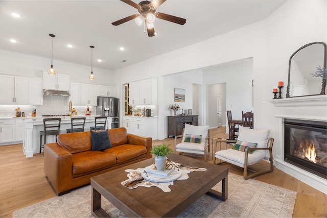 living room with light hardwood / wood-style flooring and ceiling fan