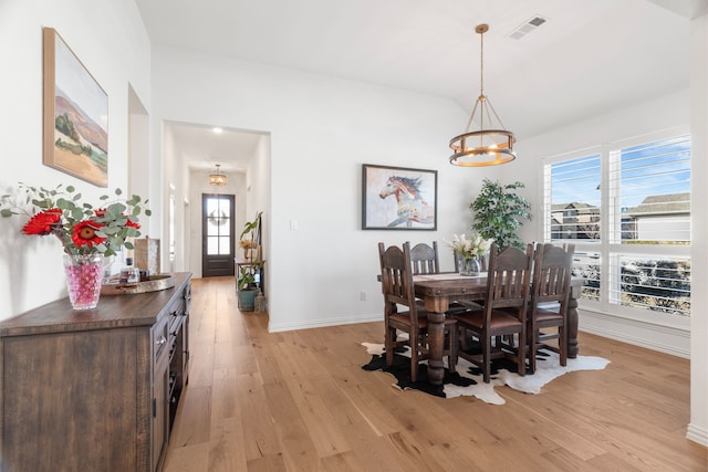 dining area with an inviting chandelier, a healthy amount of sunlight, and light hardwood / wood-style floors