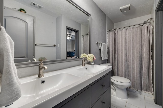 bathroom with a textured ceiling, toilet, tile patterned floors, and vanity