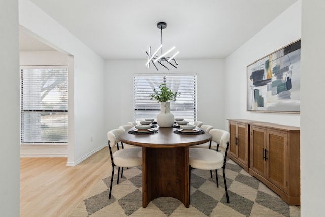 dining room featuring a notable chandelier and light wood-type flooring