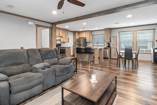 living room featuring ceiling fan, crown molding, sink, beamed ceiling, and hardwood / wood-style floors