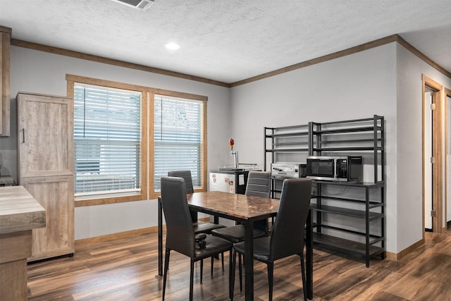 dining area with a textured ceiling, dark hardwood / wood-style floors, and ornamental molding