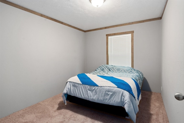 bedroom featuring a textured ceiling, carpet floors, and ornamental molding