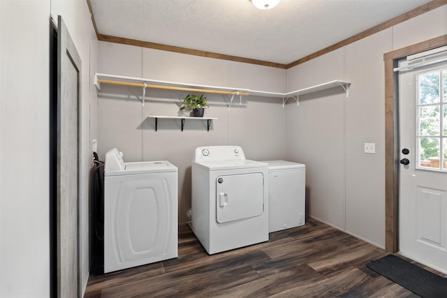 clothes washing area with washer and dryer, a textured ceiling, crown molding, and dark wood-type flooring