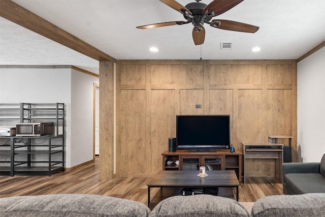 living room featuring beam ceiling, crown molding, hardwood / wood-style floors, and ceiling fan