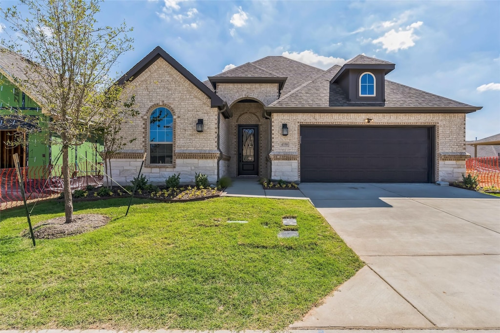 view of front of house with a garage and a front lawn