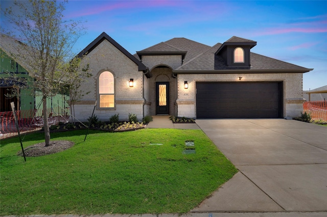 view of front of house with a yard and a garage