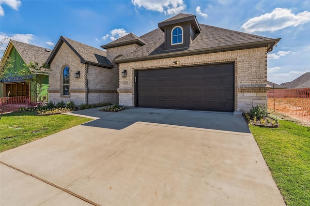 view of front of home featuring a garage and a front lawn