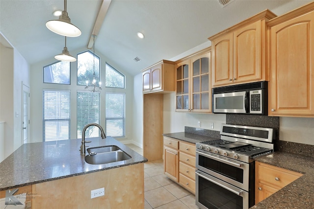 kitchen with appliances with stainless steel finishes, dark stone counters, sink, lofted ceiling with beams, and decorative light fixtures