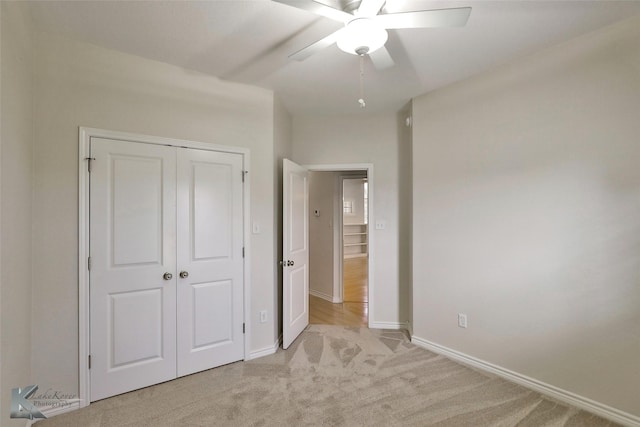 unfurnished bedroom featuring ceiling fan, light colored carpet, and a closet