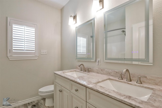 bathroom with toilet, vanity, and hardwood / wood-style flooring