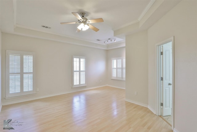 unfurnished room featuring ceiling fan, rail lighting, a raised ceiling, crown molding, and light hardwood / wood-style floors