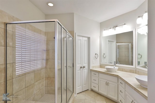 bathroom featuring tile patterned flooring, vanity, and a shower with door