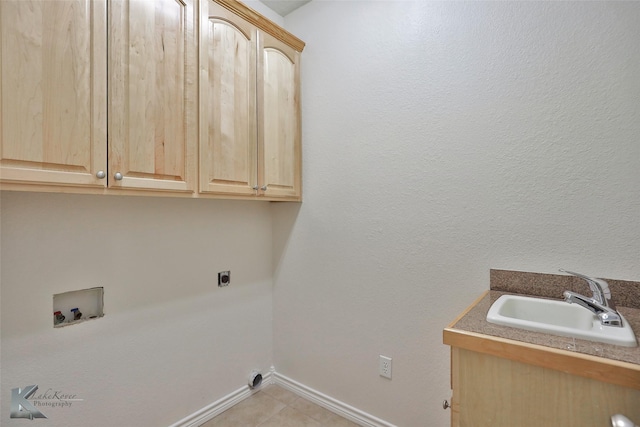 washroom with sink, cabinets, washer hookup, hookup for an electric dryer, and light tile patterned floors