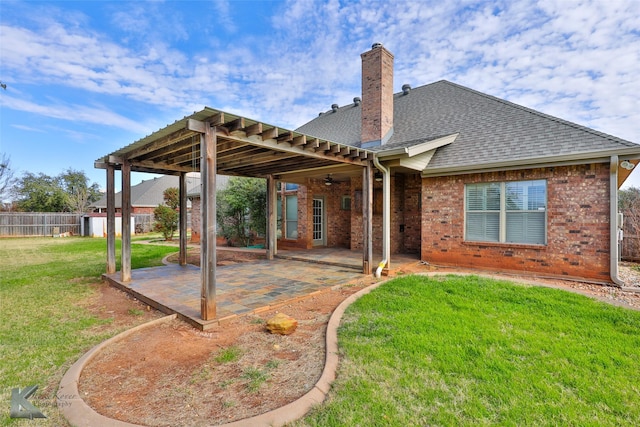 back of property with a yard and a patio area